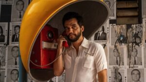 wagner-moura-personagem-do-filme-o-agente-secreto-usando-telefone-publico-tipo-orelhao