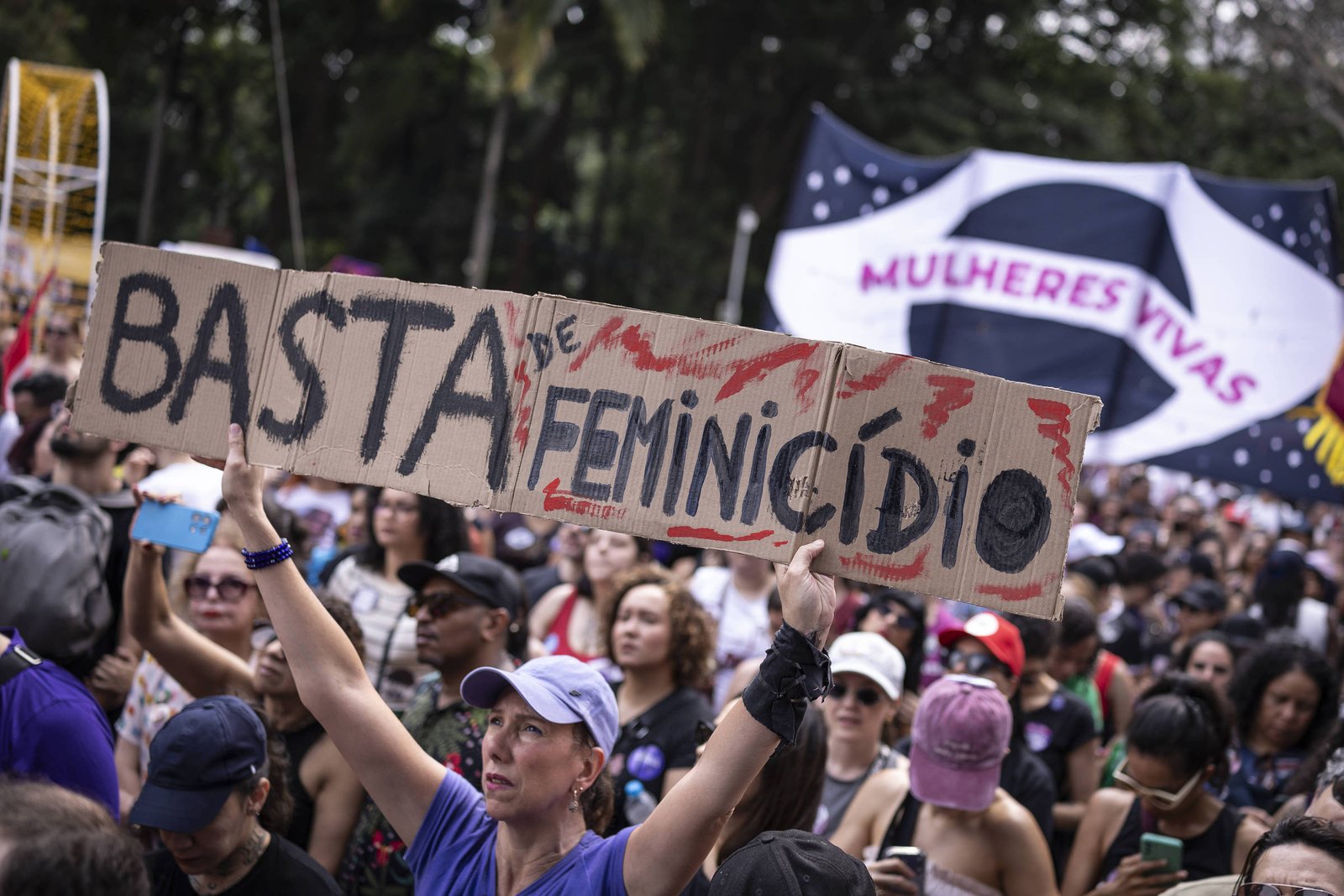 Mulher segura cartaz com a frase