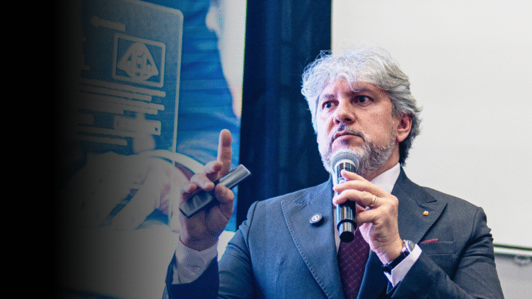Luciano Menezes durante palestra, segurando microfone e fazendo gesto técnico, em ambiente corporativo, abordando estratégia fiscal e gestão empresarial.