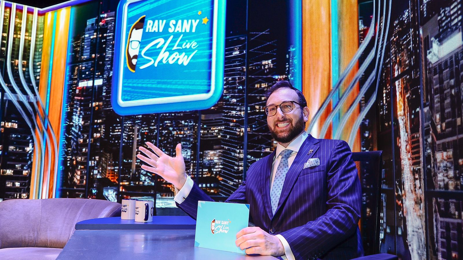 Rav Sany no cenário do Rav Sany Live Show durante gravação do programa, que passa a integrar a programação da BM&C News.