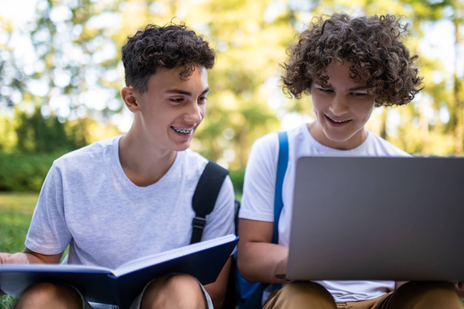 Teen boys smiling at laptop while studying