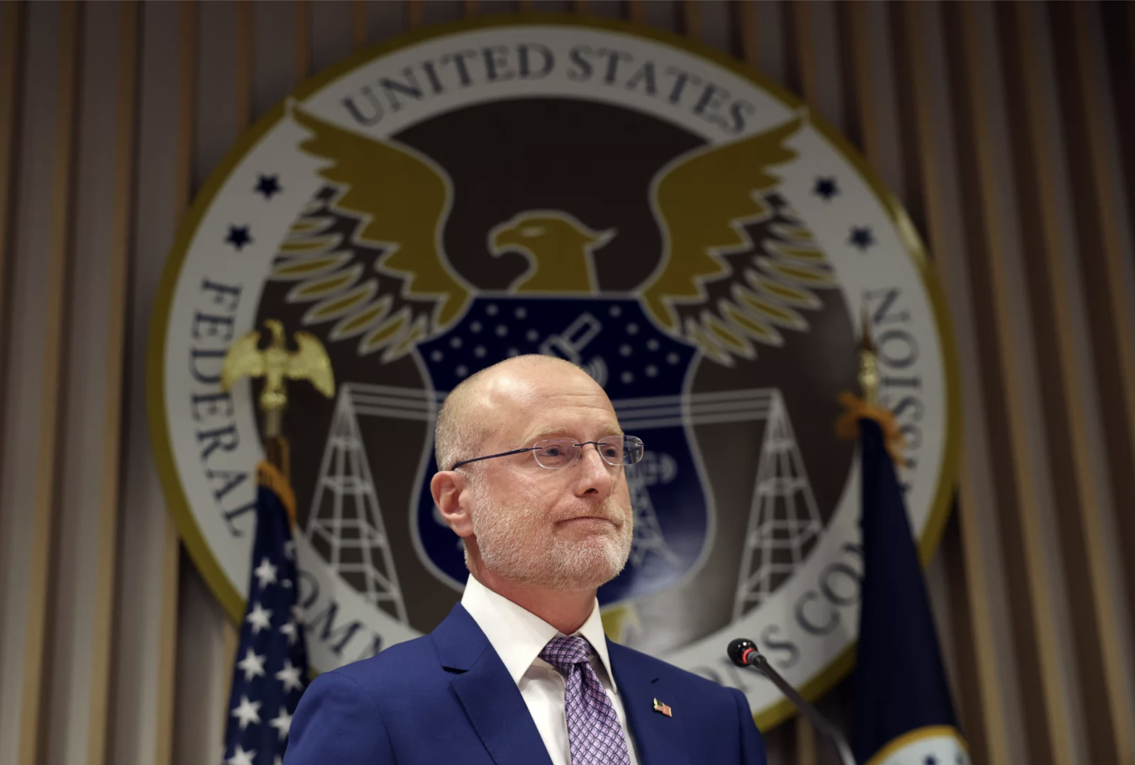 Man standing in front of government seal